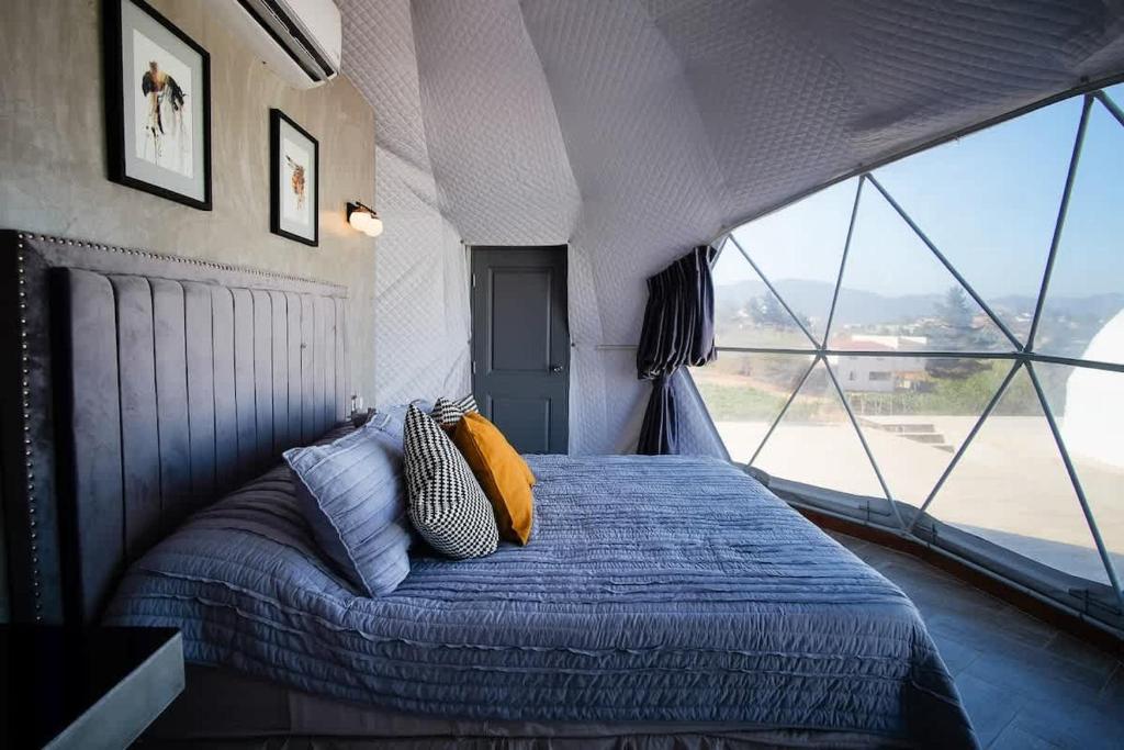 une chambre avec un lit avec une grande fenêtre dans l'établissement Cupulas Del Valle by Villa De La Rosa WiFi & AC Suite 2, à San Pablo