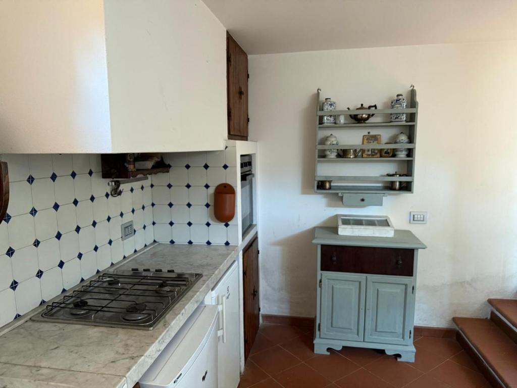 a kitchen with white cabinets and a stove top oven at Joe's apartments in Carrara