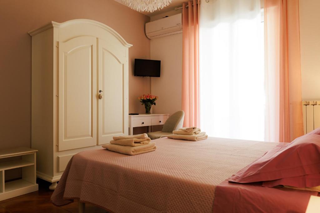 a bedroom with a bed with two folded towels on it at Bed & Breakfast L'Albero Maestro in Borgofranco dʼIvrea