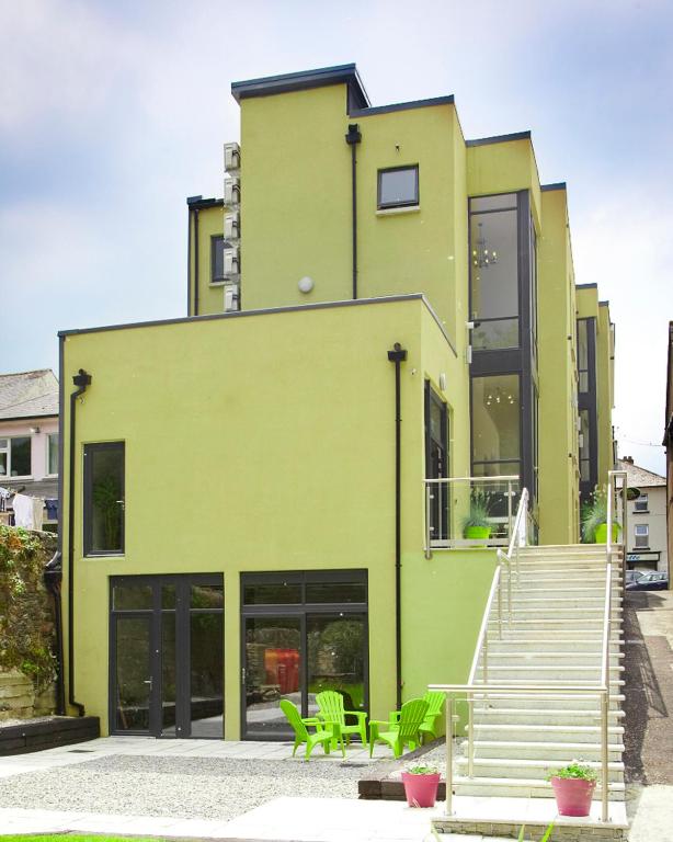 a green building with stairs and green chairs at Clody Lodge in Bunclody