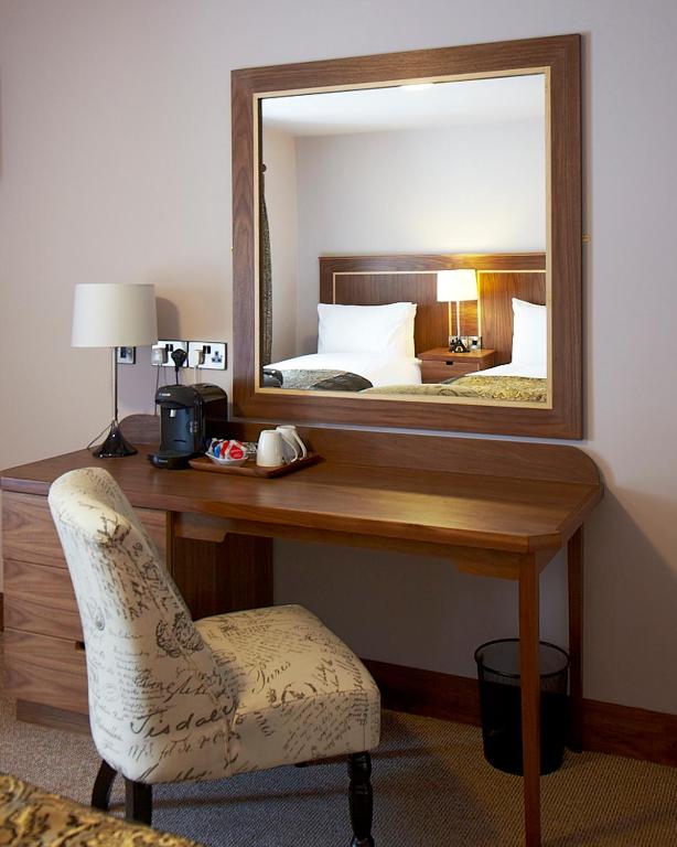 a bedroom with a desk with a mirror and a chair at Clody Lodge in Bunclody