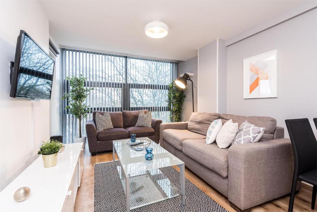 a living room with a couch and a table at Central Modern 2BR Flat with Parking & Balcony in Liverpool