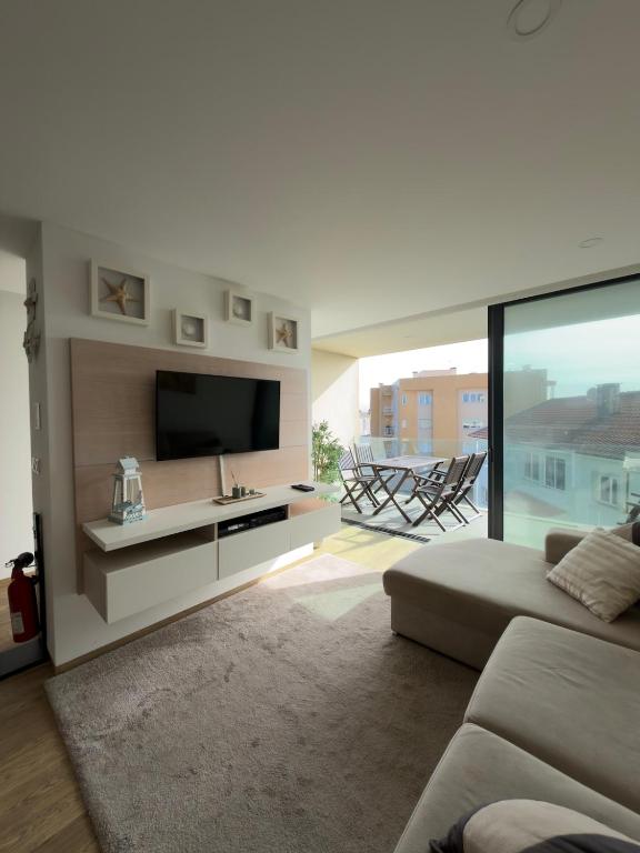 a living room with a flat screen tv and a couch at Horizonte do Mar in Apúlia