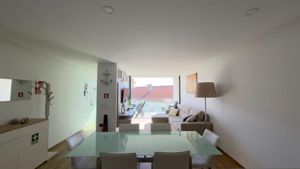 ein Wohnzimmer mit einem Glastisch und einer Couch in der Unterkunft Horizonte do Mar in Apúlia