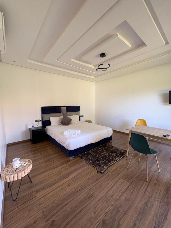 een slaapkamer met een bed, een tafel en een bureau bij Villa Sofia And Spa in Marrakesh