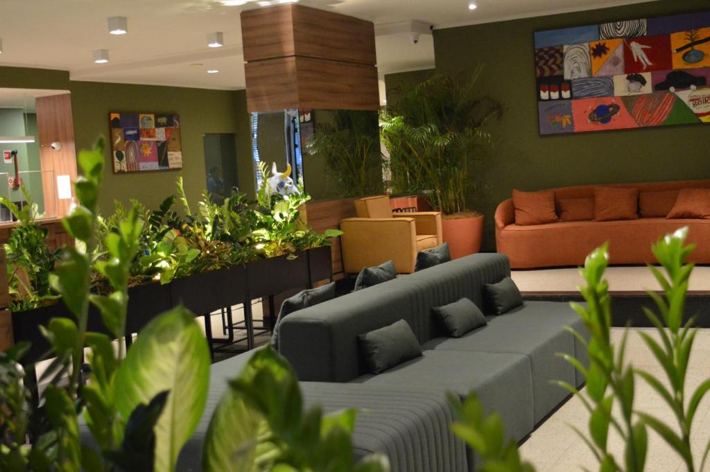 Una sala de estar con un sofá y algunas plantas. en Belém Soft Hotel, en Belém