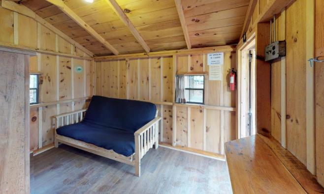 een kleine kamer met een blauwe bank in een huis bij Jellystone Park PA Wilds in Mansfield