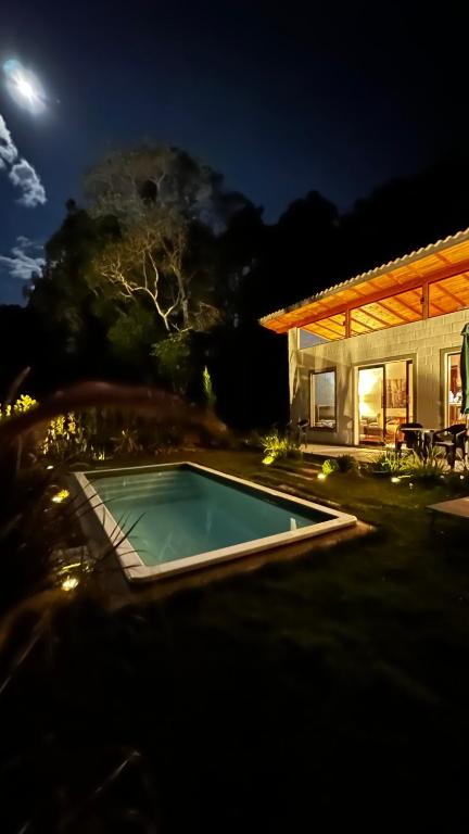 a swimming pool in front of a house at night at Villagio vilas boas Monte Verde in Camanducaia