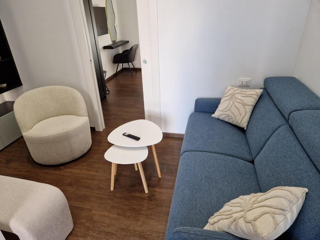 Una sala de estar con un sofá azul y una mesa. en Beki's apartment, en Alba
