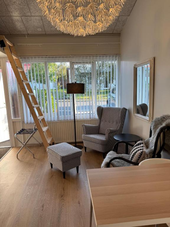 a living room with a chandelier and a couch and chairs at Nice and cozy in Bröndukvísl in Reykjavík