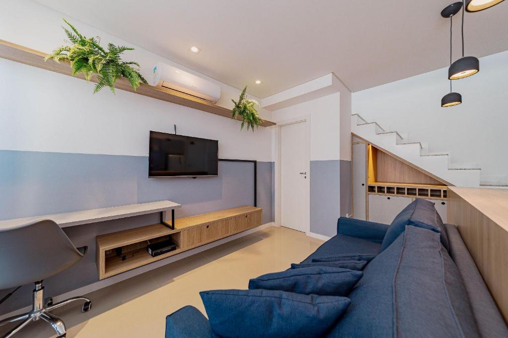 ジョインヴィレにあるWi-Fi Rápido Piscina Conforto Localização HIG807の青いソファとテレビのあるリビングルーム