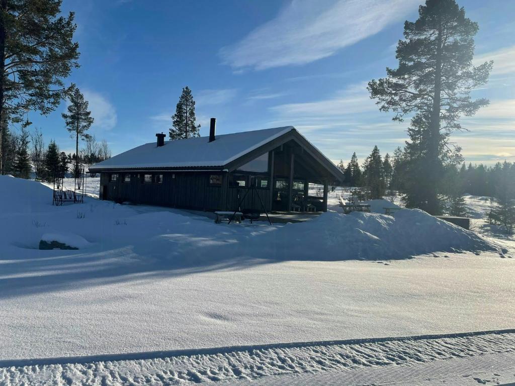 eine Hütte im Schnee mit viel Schnee in der Unterkunft Cabin With Views In Langsua National Park in Heggenes