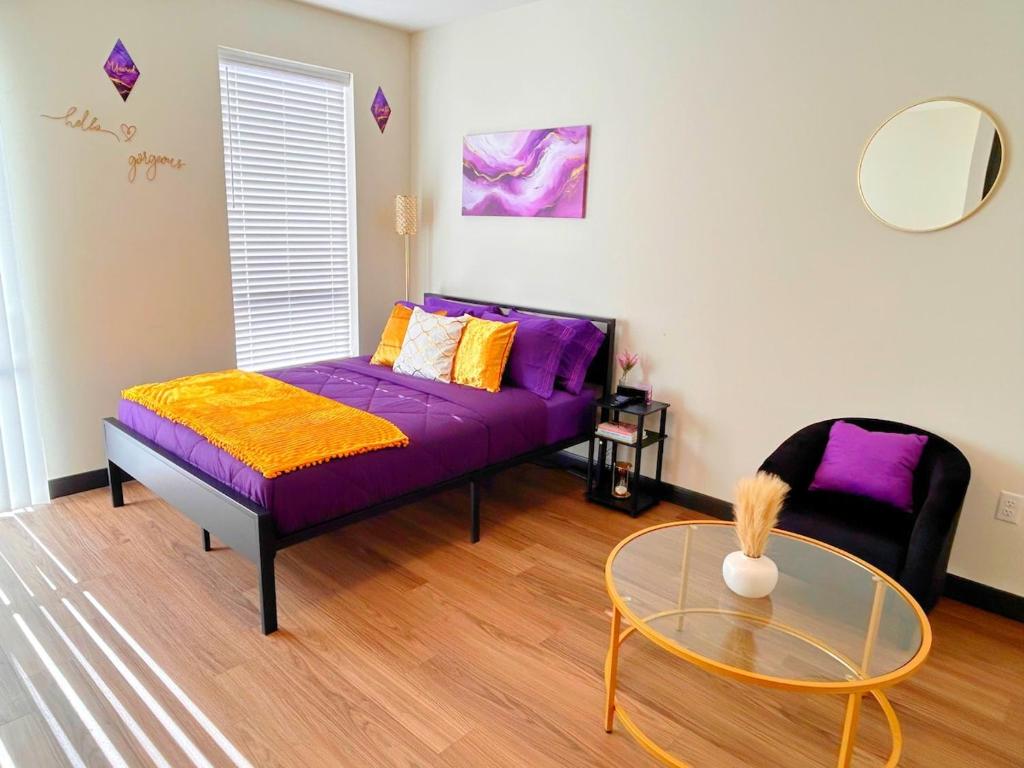 een woonkamer met een paarse bank en een glazen tafel bij Purple Palace - Downtown STL Studio in Saint Louis