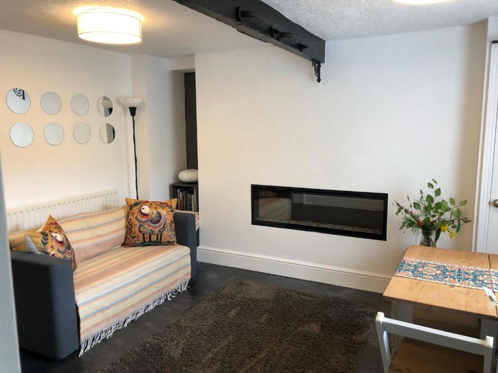 a living room with a couch and a fireplace at The Pathfinder's Retreat - 1 bedroom house 