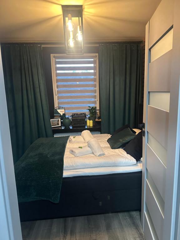 a bedroom with a large bed with green curtains at Apartament W Starym Obiektywie in Kowary