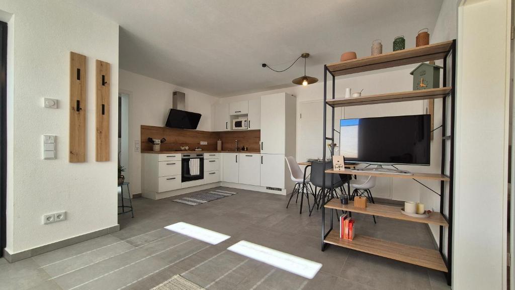 un salon avec une télévision et une cuisine dans l'établissement CasaFranken, à Wiesenthau