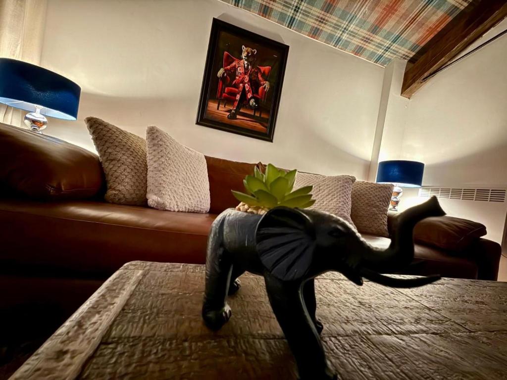 a living room with a couch and an elephant statue at The Coach House by The Hive WA1 in Warrington