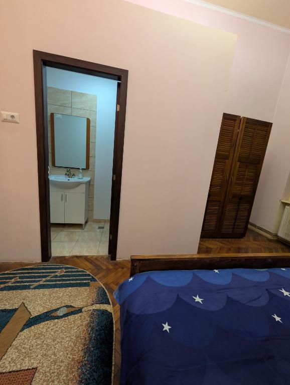 ein Schlafzimmer mit einem Bett, einem Spiegel und einem Fernseher in der Unterkunft Cazare central Craiova in Craiova