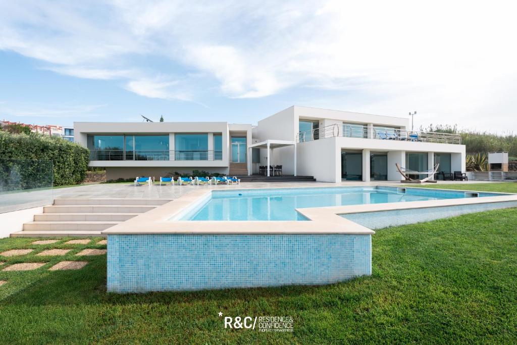 ein Haus mit einem Swimmingpool davor in der Unterkunft Casa das Areias - Surf, Golf and a wonderful sea view in Areia Branca