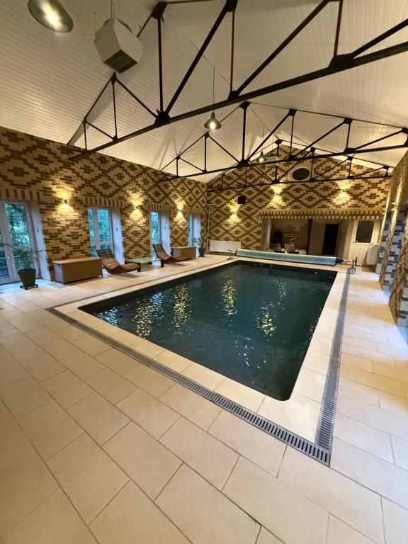 a swimming pool in a large room with a large building at La Laiterie 