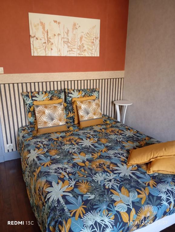 a bedroom with a bed with a blue and yellow bedspread at Appartement hyper centre 3 Lorient in Lorient