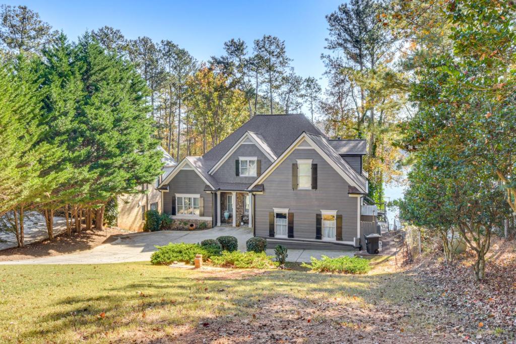 ゲインズビルにあるHome on Lake Lanier with Dock and Water Viewsの車道と木々のある灰色の家