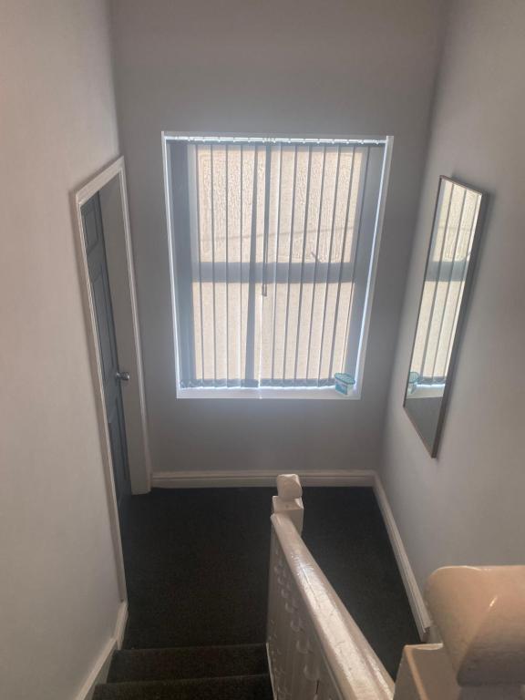 a bathroom with a staircase with a window and a mirror at wellington stay home in Wellington