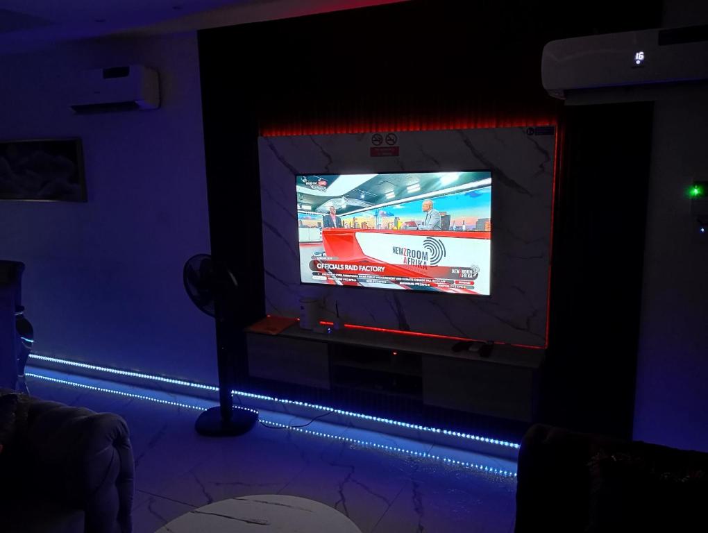a tv screen in a room with blue lights at Happy place in Port Harcourt