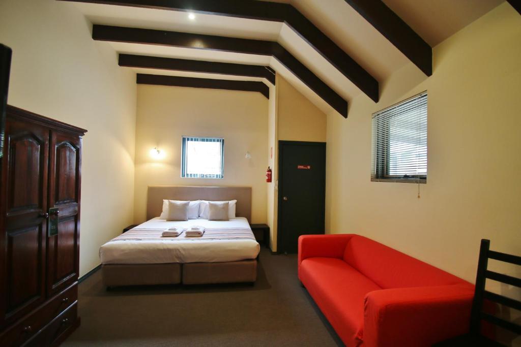 a hotel room with a bed, couch, chair and a window at Hahndorf Motel in Hahndorf