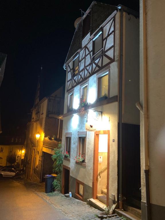 ein weißes Gebäude mit einer Tür in der Nacht auf einer Straße in der Unterkunft Das Haus - Das Marienkaeferhaus in Ürzig