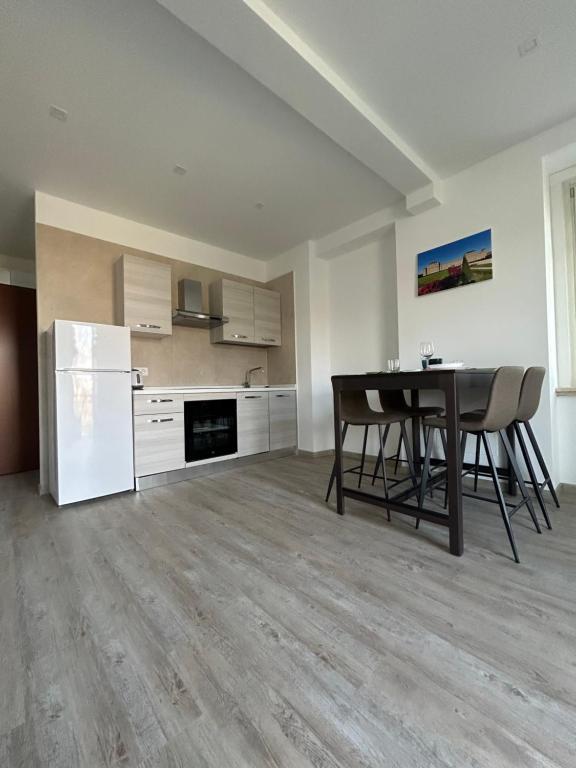 an empty kitchen with a table and a refrigerator at Appartamenti reali - I giardini reali in Venaria Reale