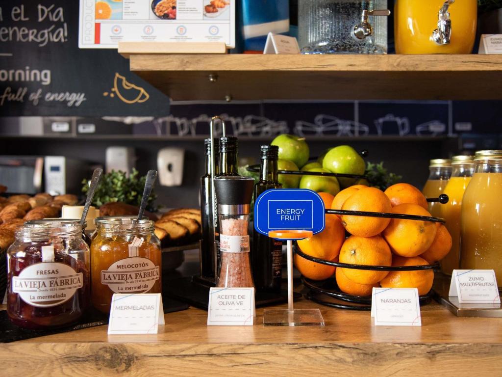 Un mostrador con un montón de frutas y tarros de miel. en Ibis Budget Madrid Calle Alcalá, en Madrid