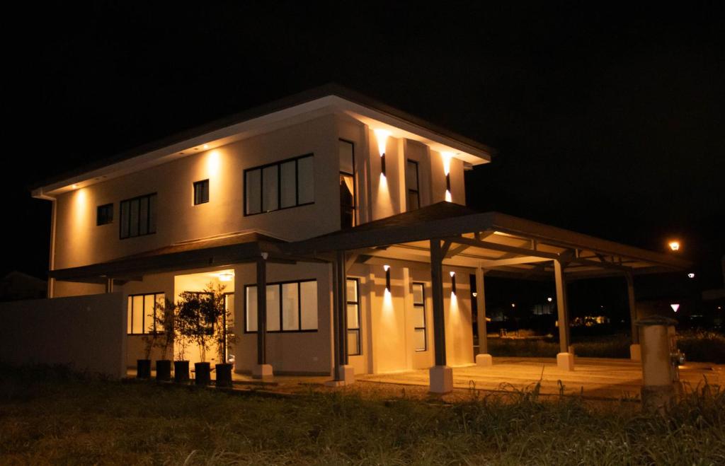 une grande maison blanche avec des lumières la nuit dans l'établissement Casa PAMPA, à Liberia