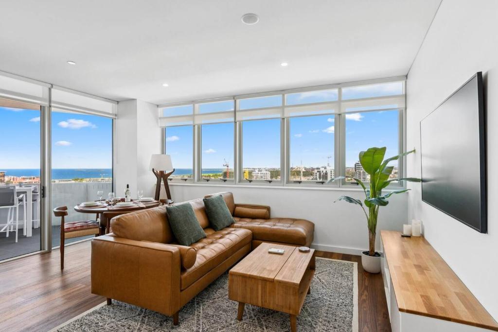 a living room with a couch and a table at Cityview Escape Poolside Living near CBD and Beach in North Wollongong