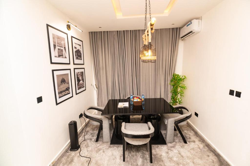 Un comedor con una mesa y sillas negras. en Luxury and Elegance, en Gwarinpa