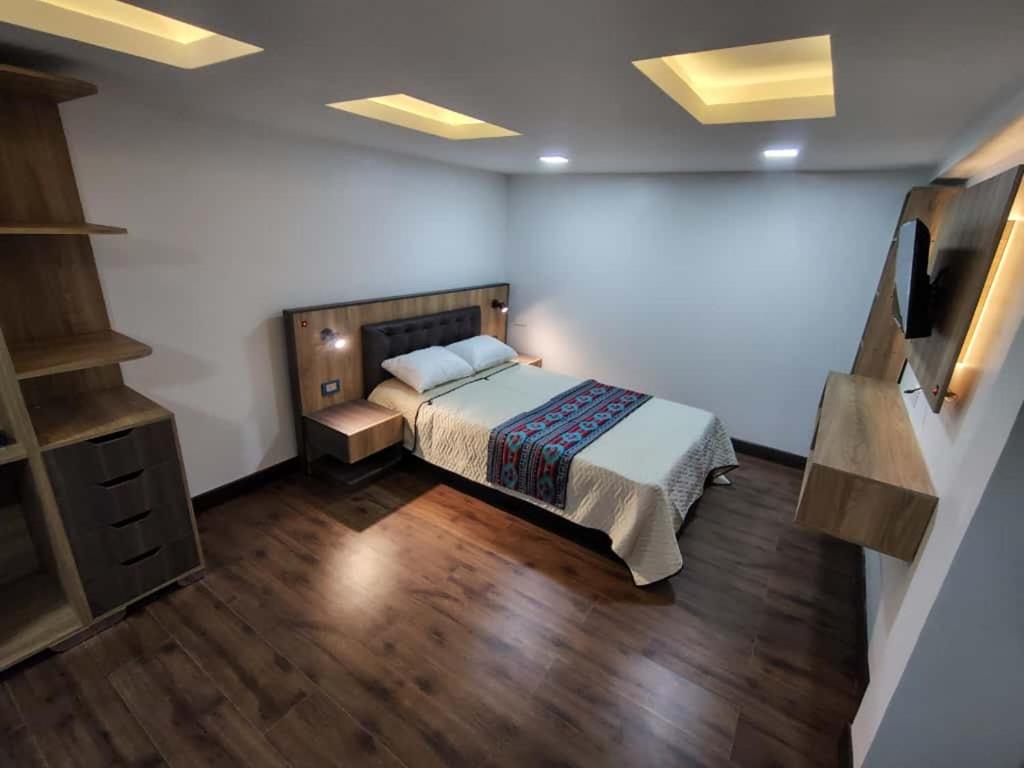 a bedroom with a bed and a wooden floor at Hotel Casa Santiago in Estación El Salto