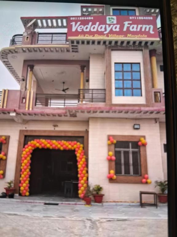 an entrance to a building with an arch of flowers at Veddaya Farm in Ghaziabad