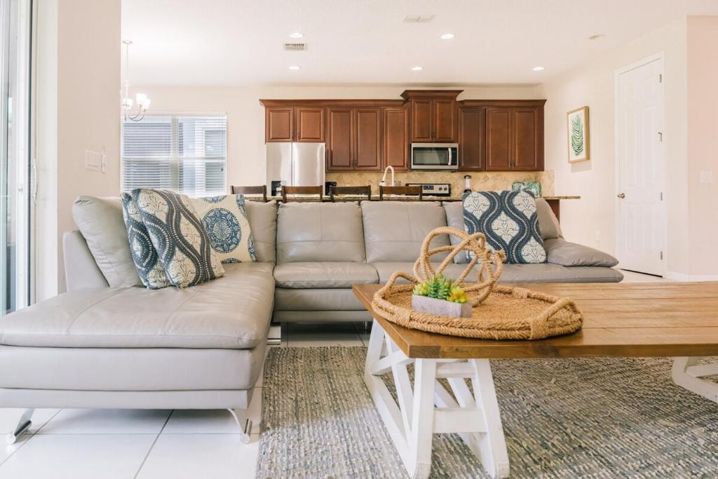 ein Wohnzimmer mit Sofa und Tisch in der Unterkunft Luxury and Spacious Villa with Pool and Hot Tub just minutes from Disney in Kissimmee