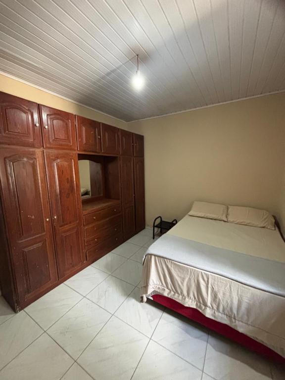 Giường trong phòng chung tại Quarto Confortável