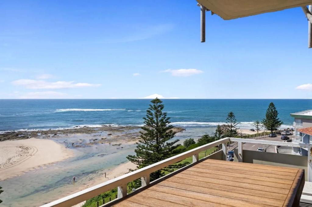 a balcony with a view of the beach at Bright Beachside Escape at The Entrance in The Entrance