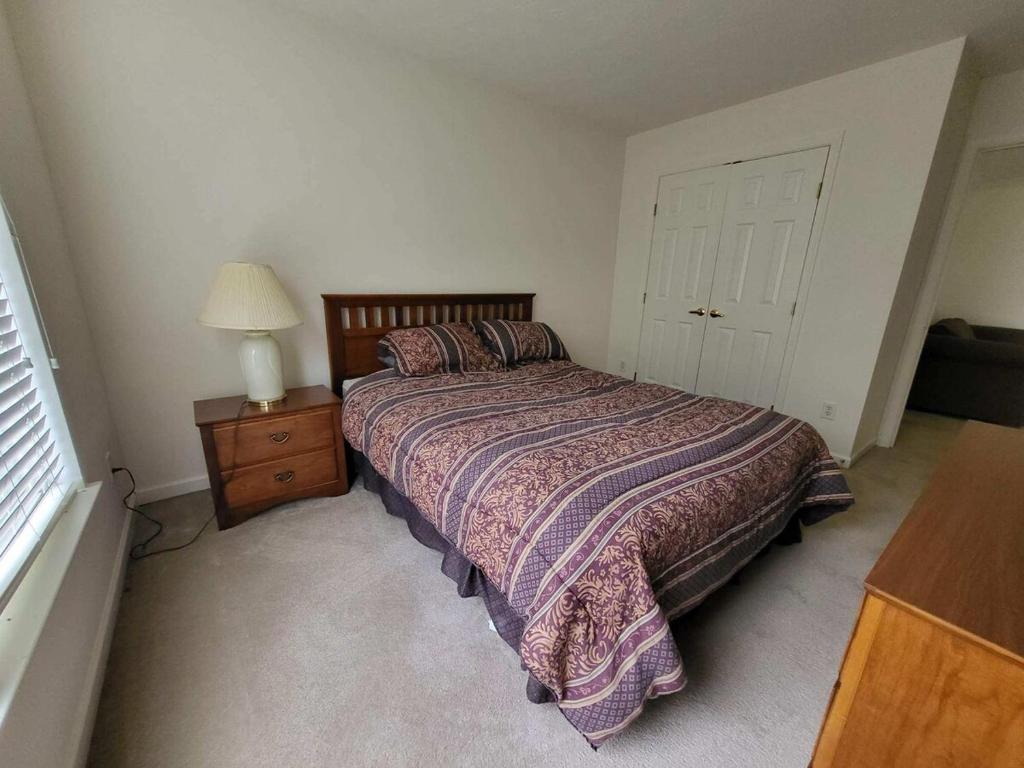 a bedroom with a bed and a lamp and a door at Dayton Gem in Dayton