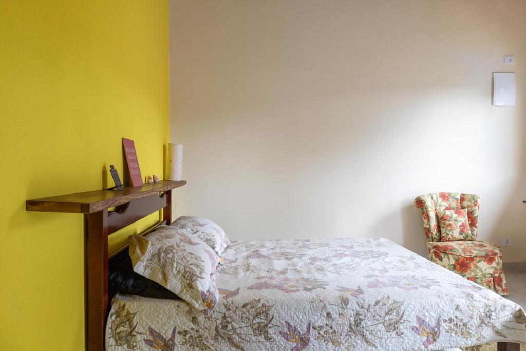 a bedroom with a bed and a table and a chair at Flor da Ilha in Estação Quitaúna