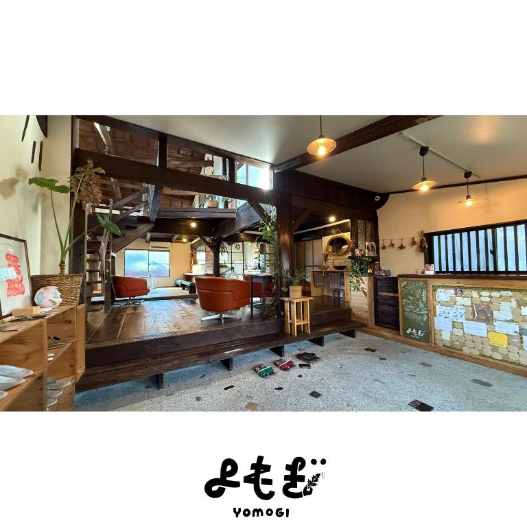 a living room with wooden floors and chairs and a room at YOMOGI GUESTHOUSE in Tokoname