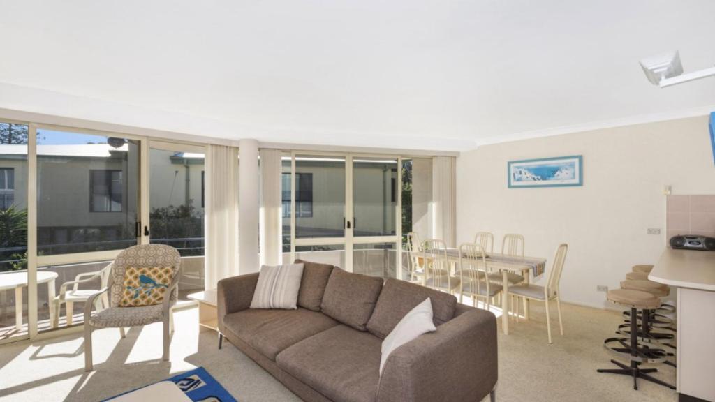 a living room with a couch and a table at Sandpiper 4 - Great Location in Avoca Beach