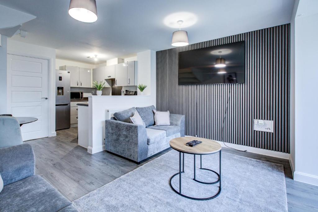 达特福德NEW! 5BR Gem by Prime Vault Properties, Town Centre Near Train Station with Driveway Parking的客厅里有一张沙发和一张桌子。