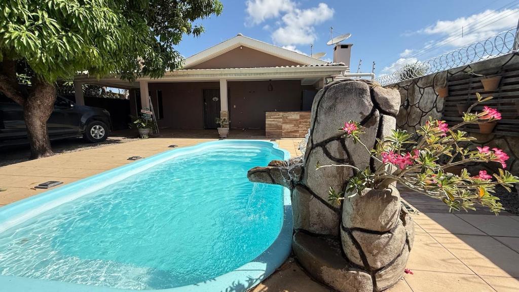 a swimming pool in front of a house at Casa ampla e confortável próxima ao shopping pátio in Boa Vista