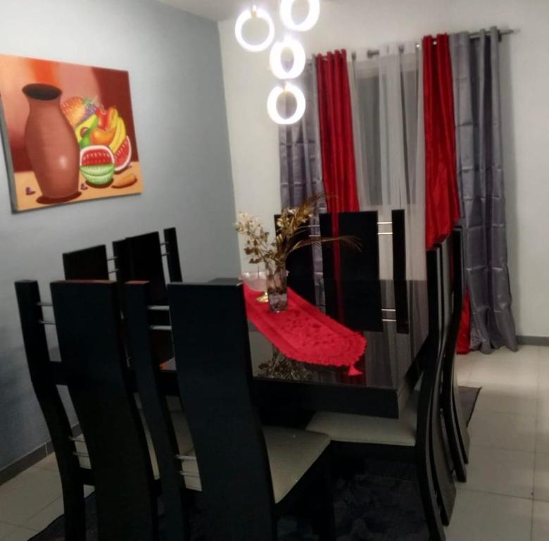 a dining room table with black chairs and a red table cloth at Hermoso apartamento in Santo Domingo