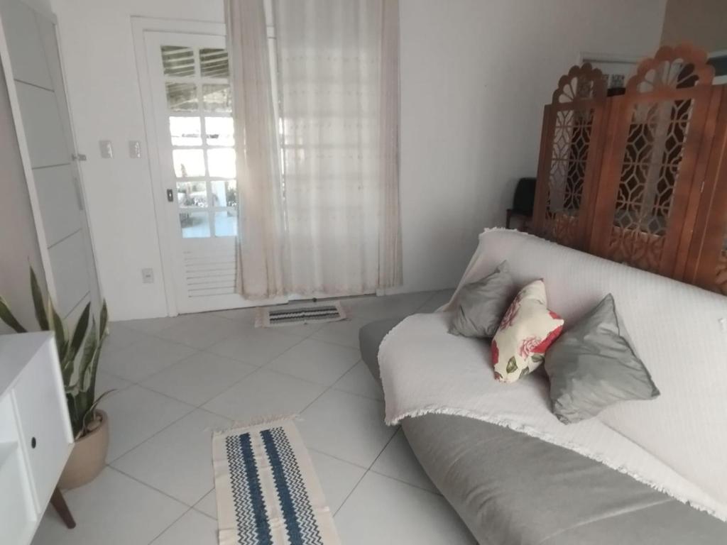 a living room with a couch with pillows on it at Lumiar Garden Suítes e Chalés em Vilas do Atlântico in Lauro de Freitas
