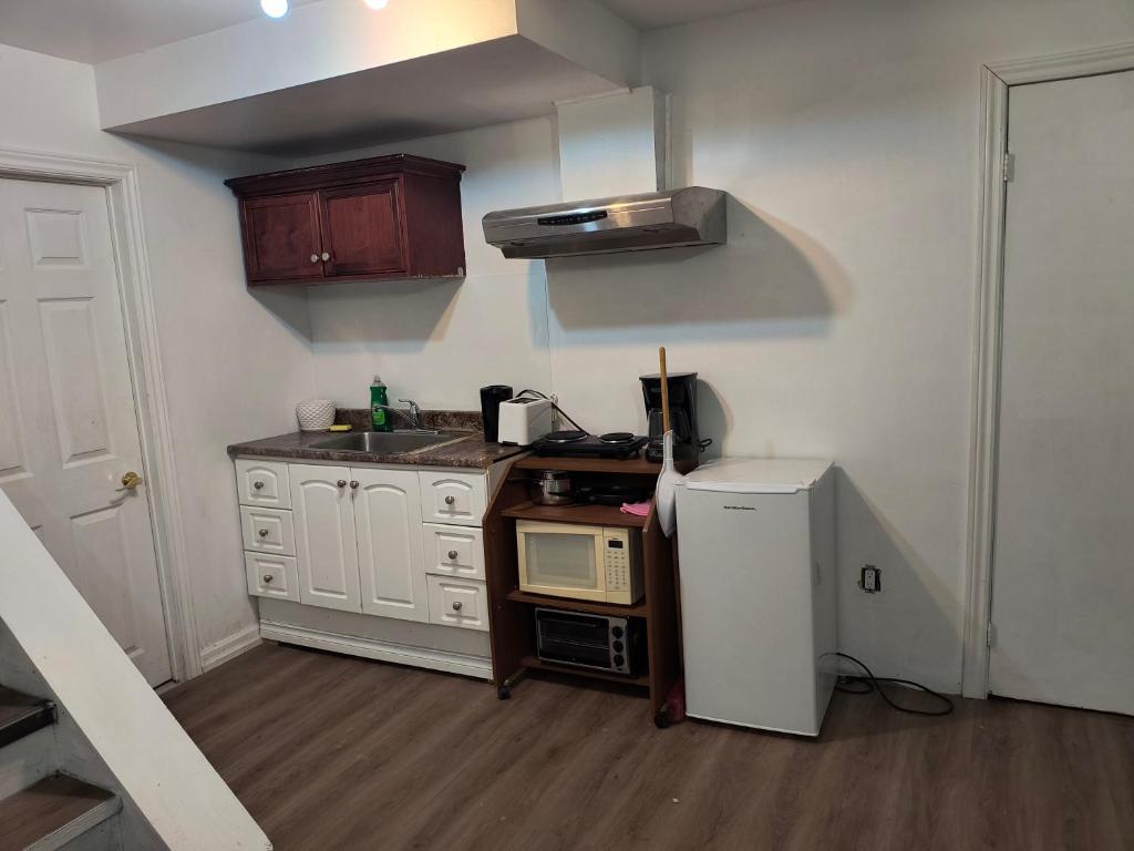 a small kitchen with a microwave and a refrigerator at Cozy Bachelor Apartment at Trillium in Kingston