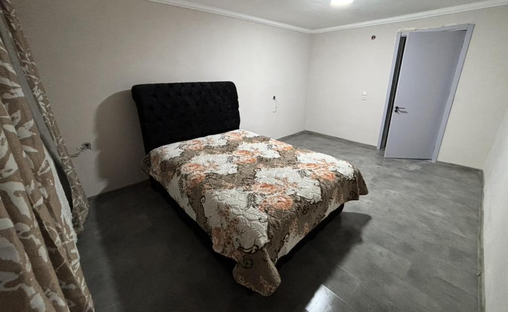 Un dormitorio con una cama en la esquina de una habitación. en wwaallee, en Kutaisi